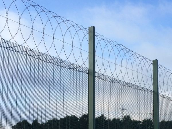 Flat wrap razor wire is installed at the tops of 358 high security fence.