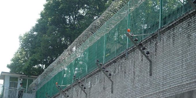 Des fils de rasoir sont installés sur le dessus du mur de protection de la prison.