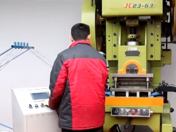 Un trabajador está operando la máquina CNC para la producción de alambre de púas.