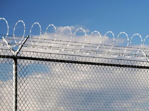 Single coil razor wires and chain link fence are used for restricted area protection.